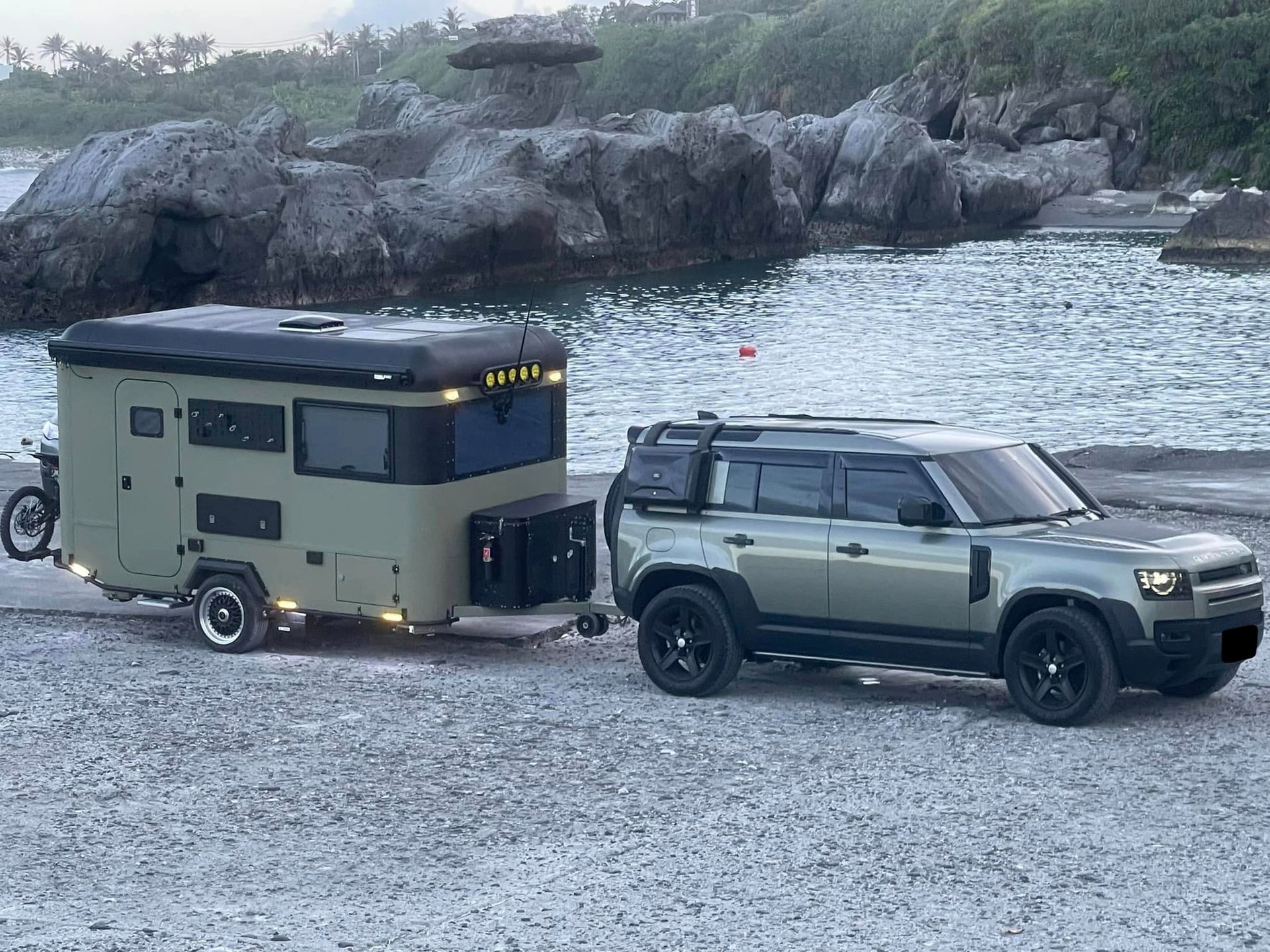 可樂屋露營拖車在海邊，由 Land Rover Defender 牽引